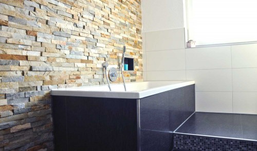 Modernes Bad mit Badewanne und Naturstein